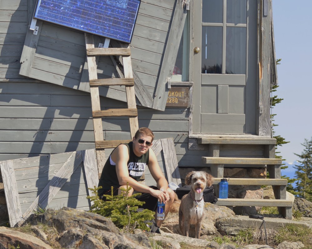 My co-worker, Thomas Kyle-Milward, and my dog, Ms. Molly, relax in the beautiful May weather. The fire lookout was built in 1932 or 1933 and was placed on the National Historical Register in 1987. (Photo by Craig Craker)